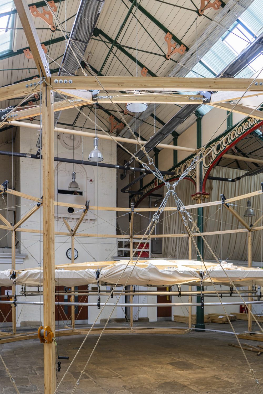 Inside the timber drum: the suspended canopy ring, rope bracing and a hand winch